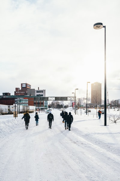 白天，人们在积雪覆盖的道路上行走